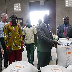 Honourable Vincent Ssempijja, Minister of Agriculture, Animal Industry and Fisheries; Honourable Earnest Kiiza, Minister of State for Bunyoro Affairs posing with a bag of feed